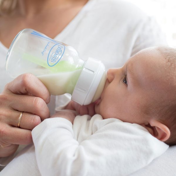Mother holding baby who is drinking from a Dr. Brown’s Natural Flow® Options+™ Glass Wide-Neck Bottle 5 ounce